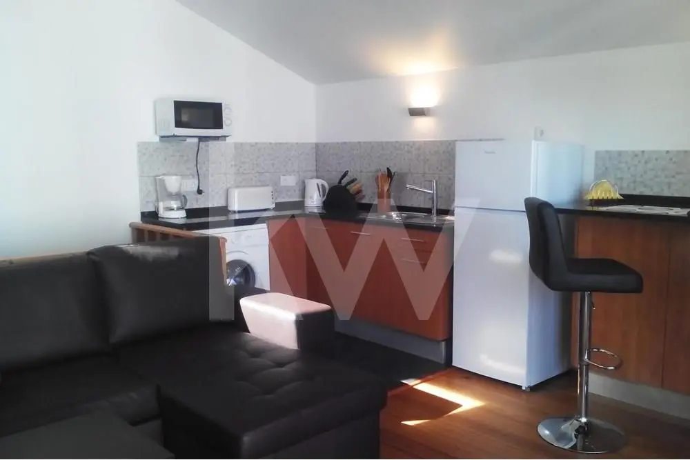 Sala com kitchenette situada no piso superior do apartamento T3 Duplex em Cascais.