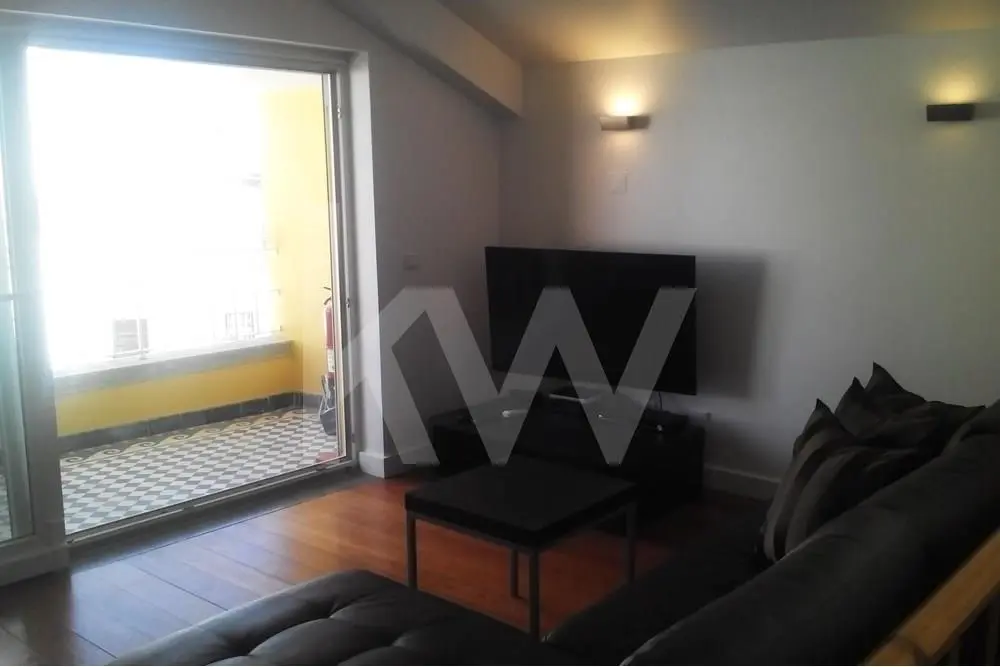 A sala está aberta sobre a varanda, proporcionando luz e uma agradável vista sobre o centro de Cascais.