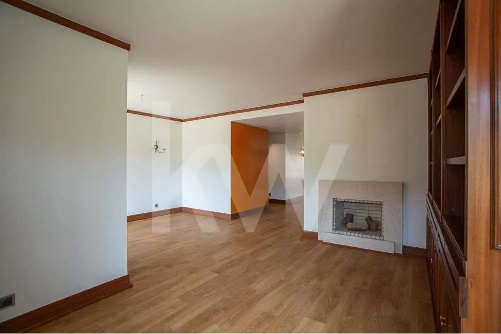 Vista da sala e da lareira do apartamento T3 no Estoril para venda, localizado no Condomínio Estoril Garden.