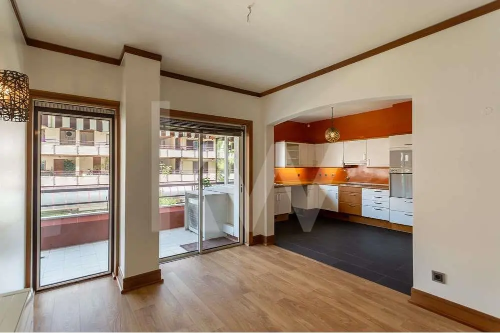 Vista da sala de refeições aberta sobre a cozinha no apartamento T3 no Estoril para venda, localizado no Condomínio Estoril Garden.