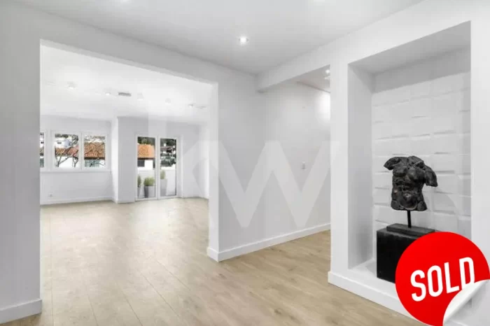 Um busto pontua esta vista do hall de entrada e da sala de estar do apartamento T4 em Cascais entretanto vendido.