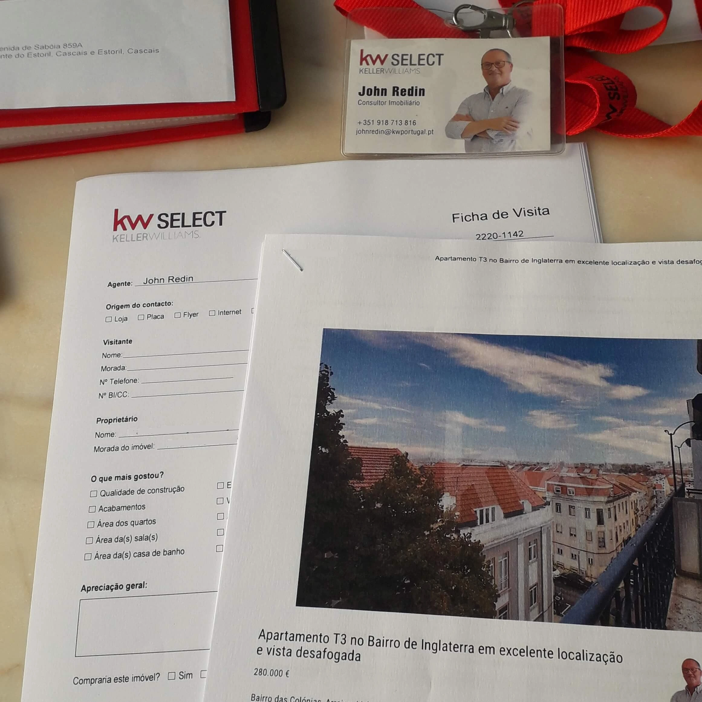 Material de trabalho do consultor imobiliário profissional John Redin sobre uma mesa, incluindo uma ficha de visita, cartão de visita e a apresentação de um apartamento para venda.